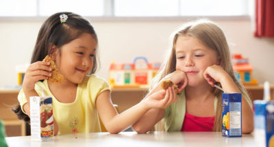 Two students acting with kindness by sharing.