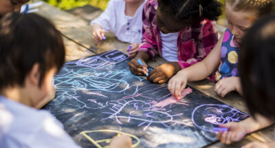 students write with chalk on