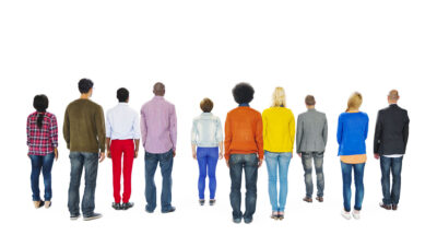 A diverse group of people standing, with their backs facing the viewer