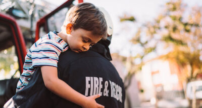 Firefighter carrying little boy after successful rescue operation