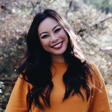 Smiling Asian woman in a yellow sweater