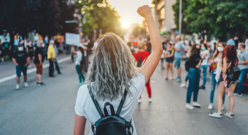 Young woman with a raised fist protesting in the street