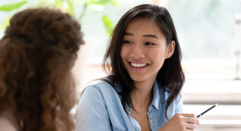 Asian teenage girl talking with a classmate