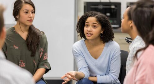 Teenage girl talking with classmates