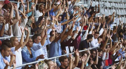 People doing the wave on the sport or music event.