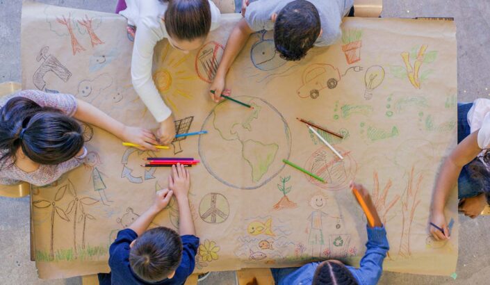 A group of students drawing a mural that highlights many SEL skills