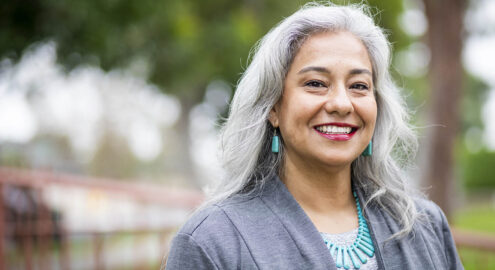 Hispanic woman principal smiling on campus