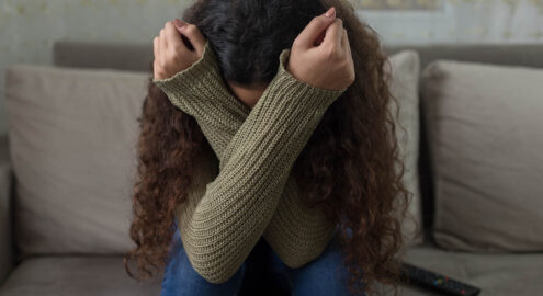 student covers face while crying