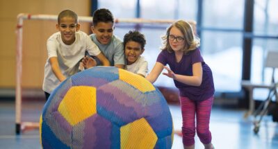 Kids playing with a giant soccer ball in after school program