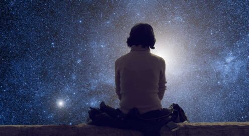 Young woman sitting on the ground and watching the stars. Stars are digital illustration.