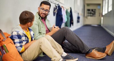 Teacher talking to young sad student