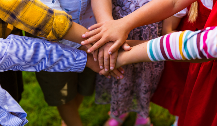 Kids putting their hands together