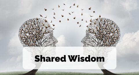 Two trees in the shape of silhouettes face each other and birds pass between them, to signify the sharing of wisdom and ideas. The words Shared Wisdom are overlayed on top of the image.