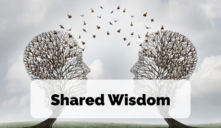 Two trees in the shape of silhouettes face each other and birds pass between them, to signify the sharing of wisdom and ideas. The words Shared Wisdom are overlayed on top of the image.