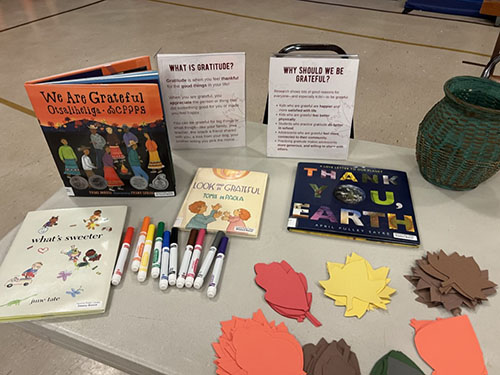 Table with books, instructions, markers and various colored leaves.