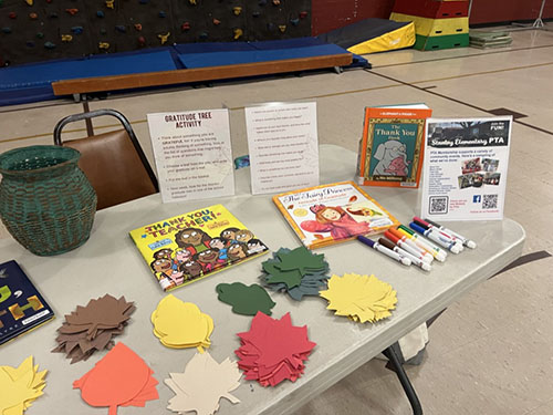 Table with books, instructions, markers and various colored leaves.
